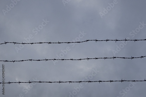 Barbed Wire Fence Danger Security Prison Zone Secret Territory Object and Rainy Storm Weather Sky Clouds
