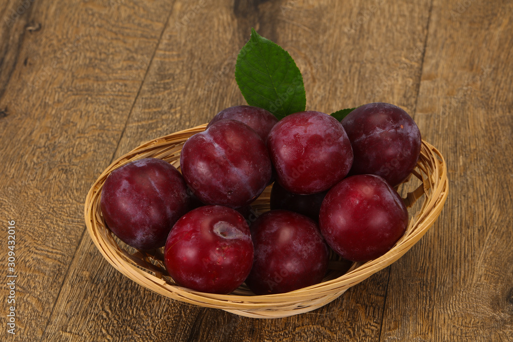 Plum heap in the wooden basket Plum heap in the wooden basket