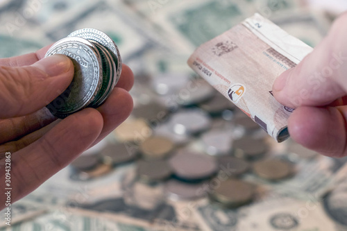 Hand holding georgian lari coins and banknotes against usd american dollar background with russian ruble rub coins