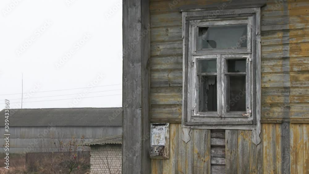 Abandoned, ruined old wooden house. Windows and wall with damaged old roof with weathered paint. Close-up. 4k.