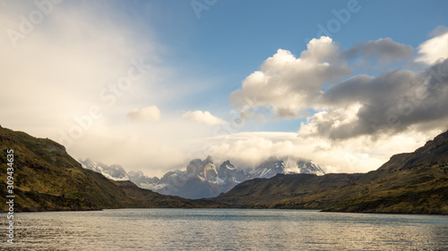 Clouds and blue sky in the Torres del Paine mountains that overlook the waters of a lake, Torres del Paine National Park, Chile