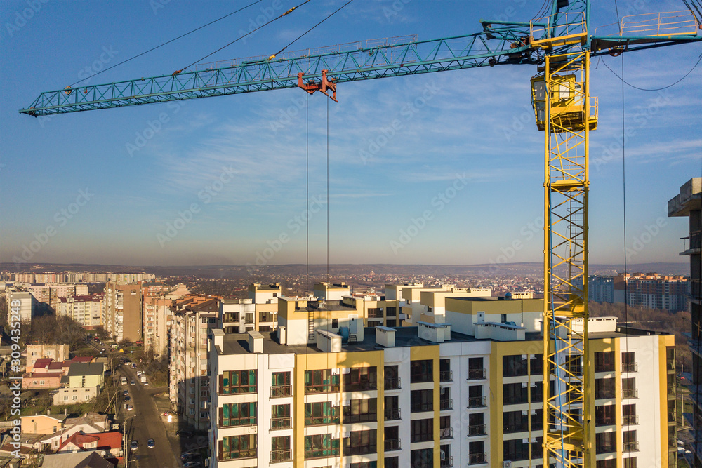 Aerial view of concrete frame of tall apartment building under construction in a city.