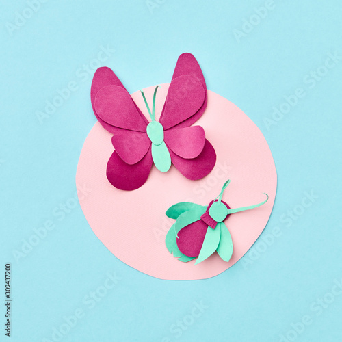 Creative round frame with craft pink paper butterflies on a blue background. Flat lay. Copy spae.