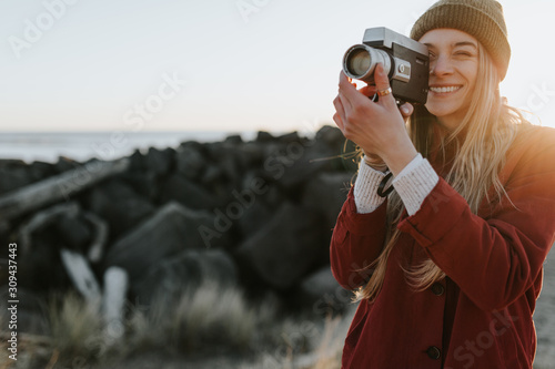 Woman filming with vintage camera photo