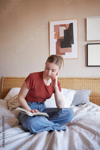 A woman reading on her bed. photo