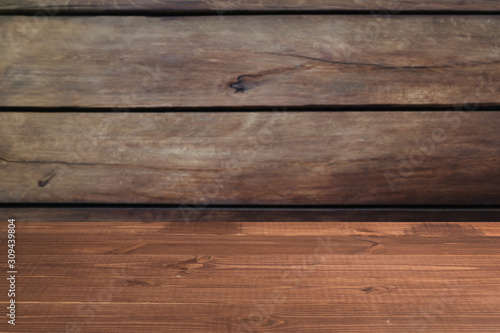 Wooden board empty table in front of a blurred background. Perspective brown wood with blurry grunge or old wall backdrop - can be used to showcase or mount your products.