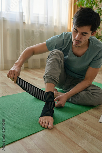 Fit man banding foot and ankle photo