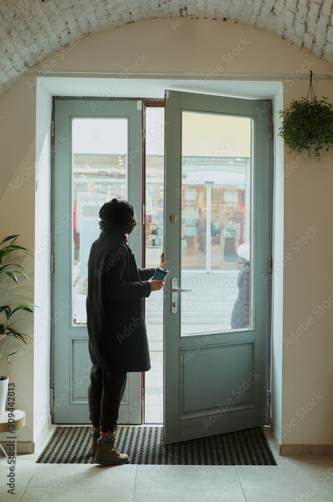 Woman walking out with coffee Woman walking out with coffee