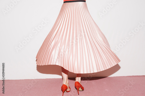 woman with pink pleated skirt, dancing