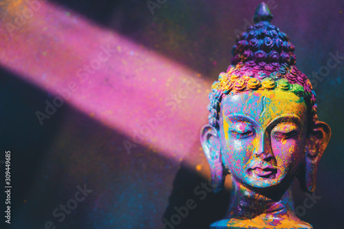 Colorful, vibrant Buddha figurine painted in bright, rich colors photo