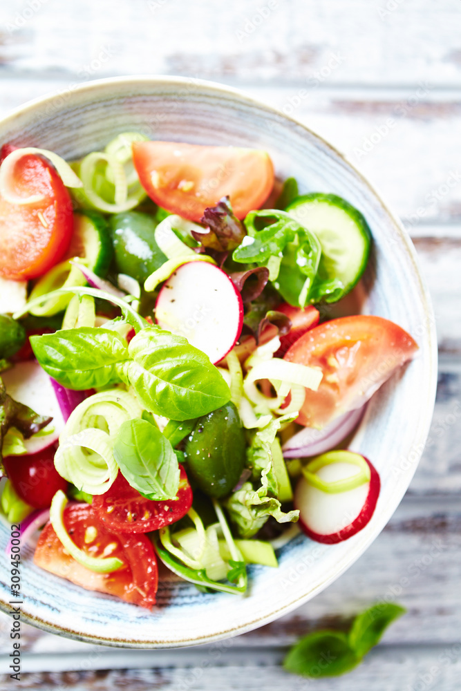Healthy Salad with Cherry Tomatoes, Green Olives, Radish, Leek, Lettuce and Fresh Basil. Easy summer snack. Bright wooden background. Top view. Healthy Salad with Cherry Tomatoes, Green Olives, Radish, Leek, Lettuce and Fresh Basil. Easy summer snack. Bright wooden background. Top view.