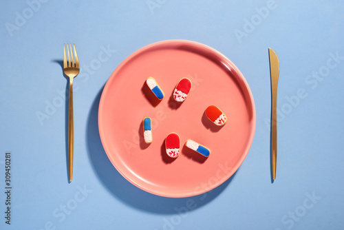 Pills on plate with fork. Pill instead of food. photo