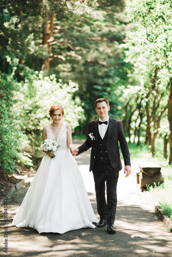 Happy wedding couple walking in a botanical park