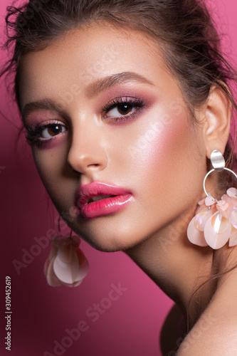 Fashion portrait of a beautiful girl with trendy pink makeup, accessories and background. Brunette model with hazel eyes