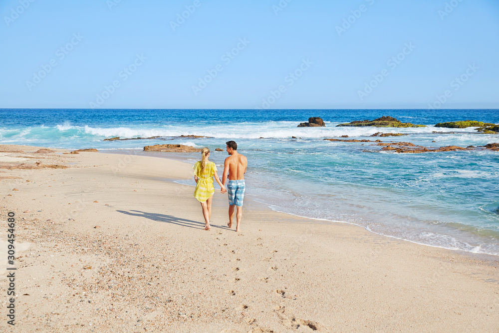 Romantic couple walking on the beach at a resort in Mexico Romantic couple walking on the beach at a resort in Mexico