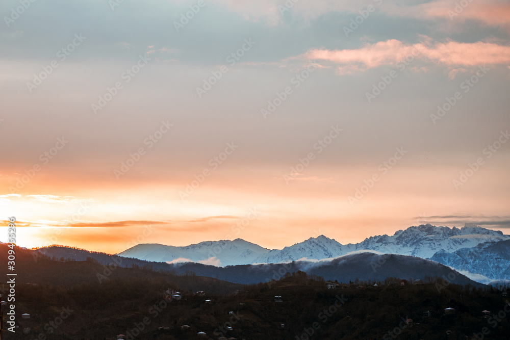 Dawn landscape on a background of snowy mountains in the fog early in the morning Dawn landscape on a background of snowy mountains in the fog early in the morning
