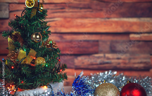 New Year and Christmas-decorated fir tree and beautiful toys with tinsel with snow on a wooden background