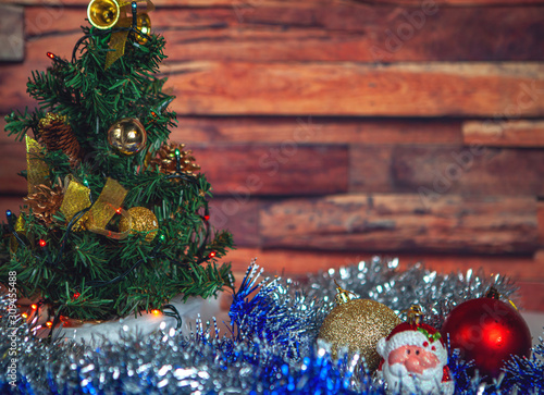 New Year and Christmas-decorated fir tree and beautiful toys with tinsel with snow on a wooden background