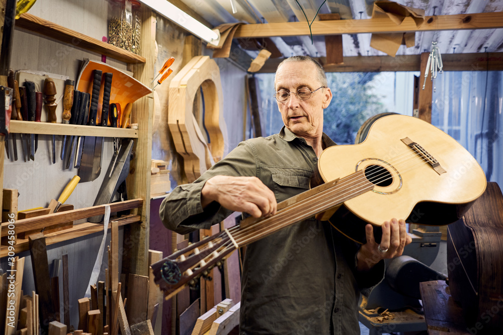 craftsman making a guitar in his woodwork workshop craftsman making a guitar in his woodwork workshop