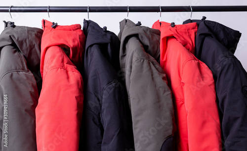 family concept or showroom of down jacket winter parka hanging on a hanger in the wardrobe