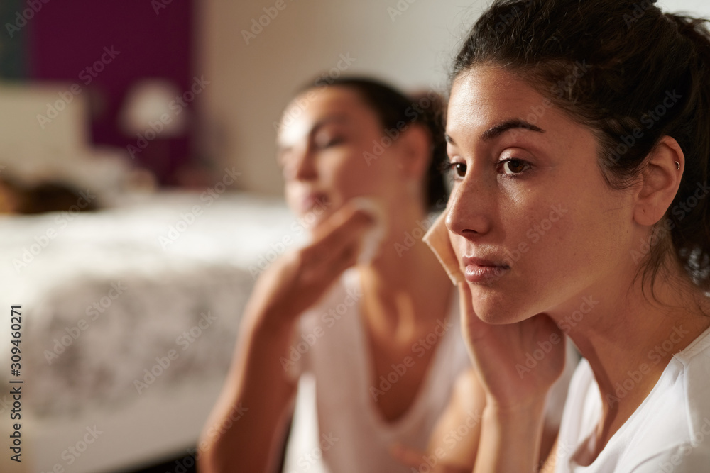 Beautiful women removing makeup with napkins Beautiful women removing makeup with napkins