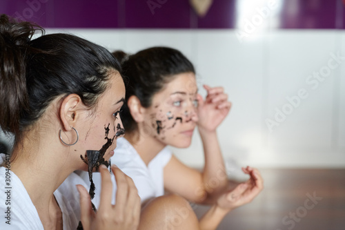 Girls removing black mask from faces photo