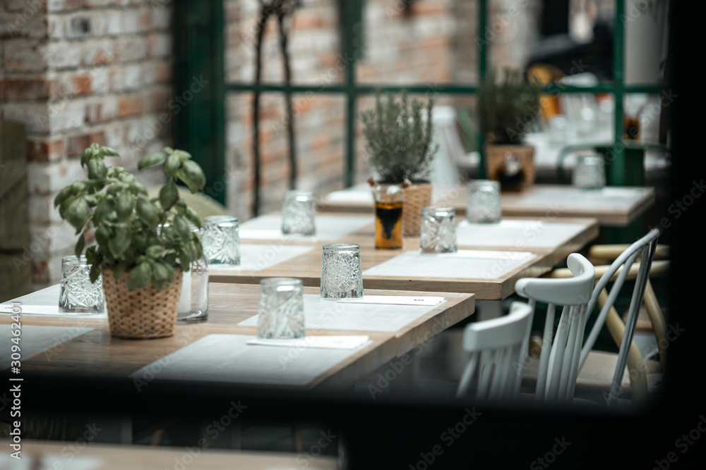 beautifully laid tables with glasses and appliances at night in restauran with blur background beautifully laid tables with glasses and appliances at night in restauran with blur background