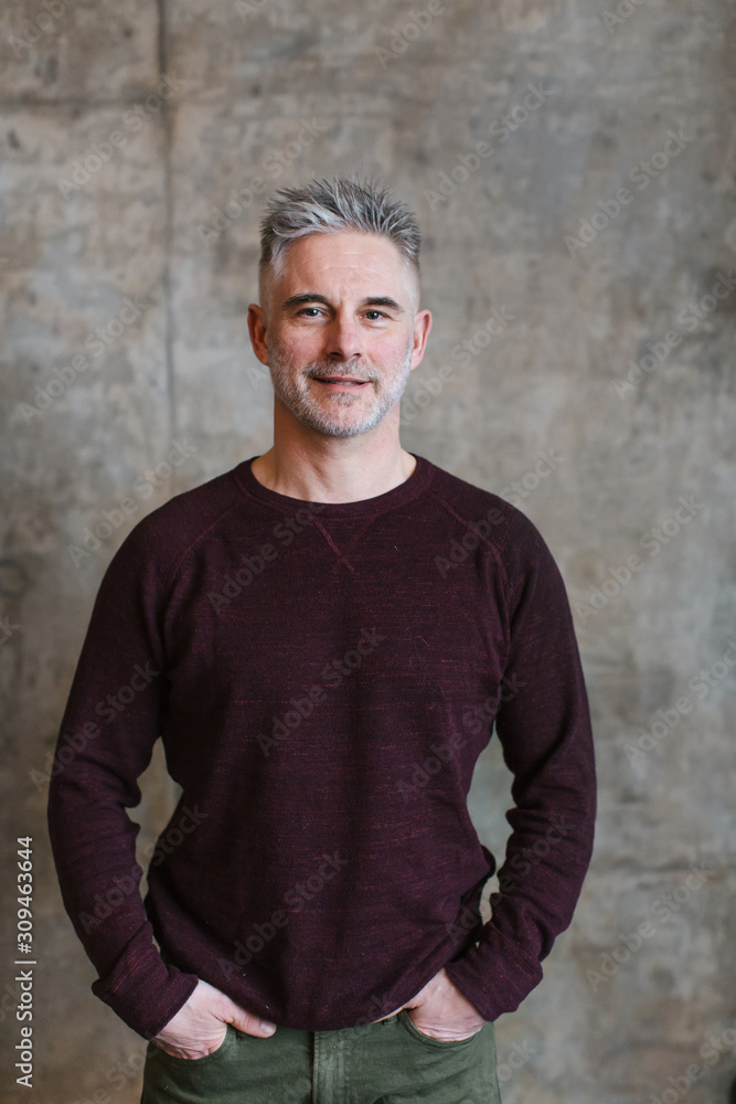 Portrait of grey haired man on concrete wall background. Portrait of grey haired man on concrete wall background.