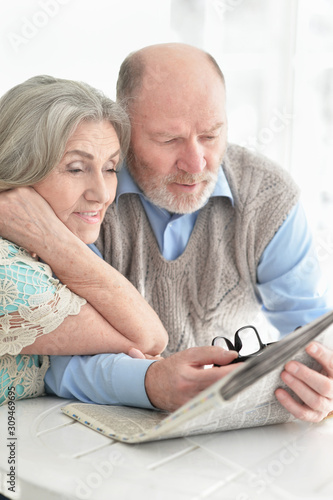Portrait of a senior couple with newspaper at home