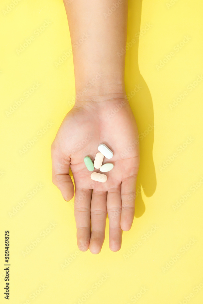 Multiple colors pills in hand Multiple colors pills in hand