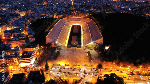 Aerial drone night shot of illuminated beautiful ancient stadium of Kalimarmaro or Panathenaic where first classic Olympic games were held at dusk with beautiful colours, Athens, Attica, Greece