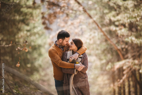 Good-looking Caucasian couple looking each other with love and affection and embracing in the forest.
