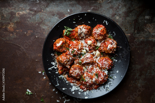 Beef and pork meatballs with parmesan cheese and parsley garnish photo