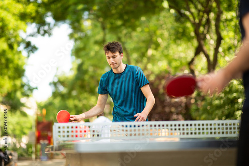Foto young man playing table tennis in park