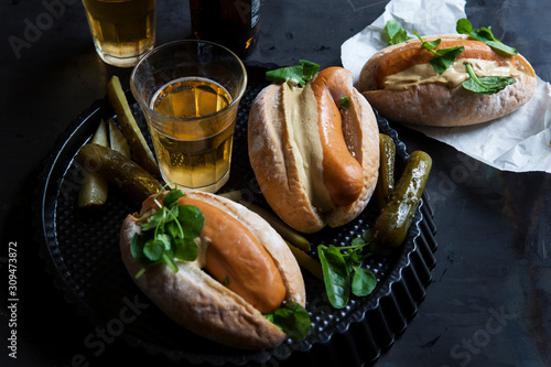 Hotdogs with mustard, pickle and a glass of beer photo