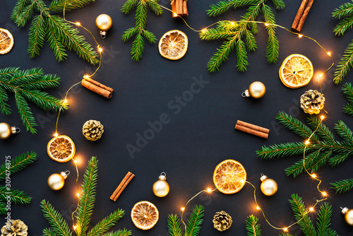 Flat lay composition for your christmas greeting or message - empty place in the center and natural xmas decorations around with magical lights.
