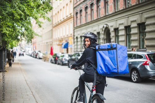 Wallpaper Mural Portrait of smiling delivery woman with bicycle on street in city Torontodigital.ca