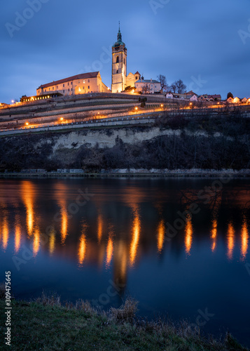 Scenic view of the historic old town Melnik in the Central Bohemia at twilight. Gothic cathedral and castle on top of hill with vineyards by the river