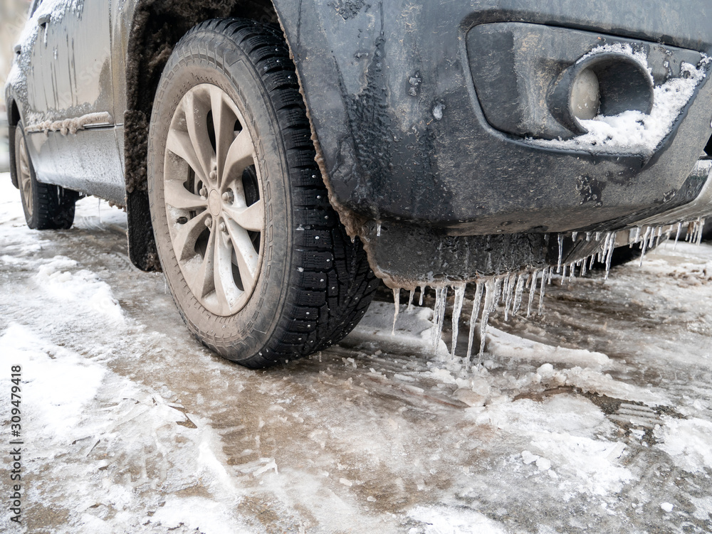 Icy front bumper of the car on the right side.