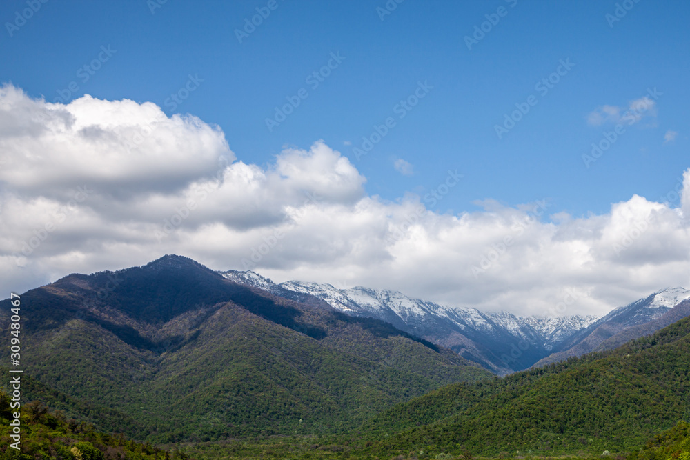 Fototapeta premium Mountain landscape, snowy peaks, clouds in the sky.