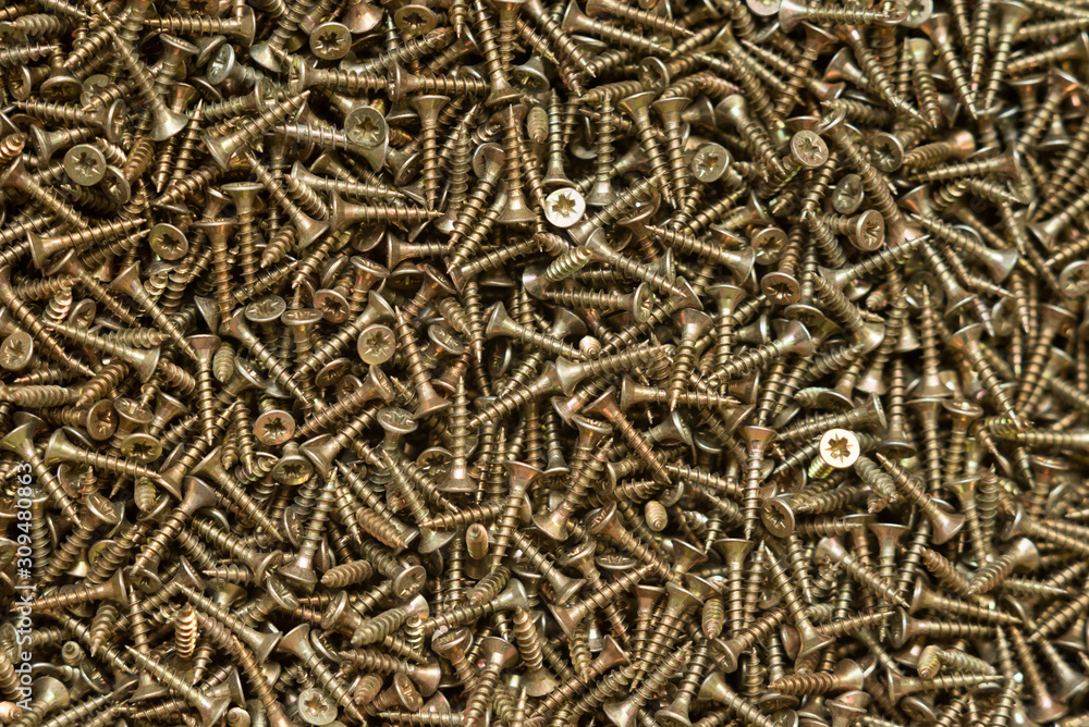 Yellow self-tapping screws with countersunk head, background. Yellow self-tapping screws with countersunk head, background.