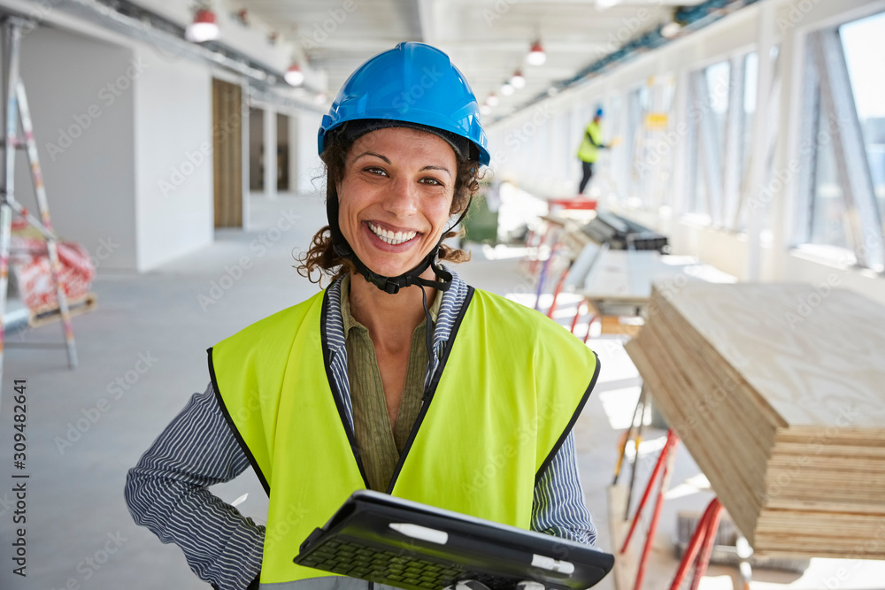 Portrait of smiling female engineer with digital tablet standing at construction site Portrait of smiling female engineer with digital tablet standing at construction site