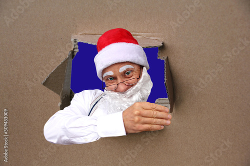 Santa Claus with a beard holds a beautiful blank, blank, old paper poster, cardboard, blank for the designer, pattern for announcements, invitations, congratulations, calendar, mock up, copy space