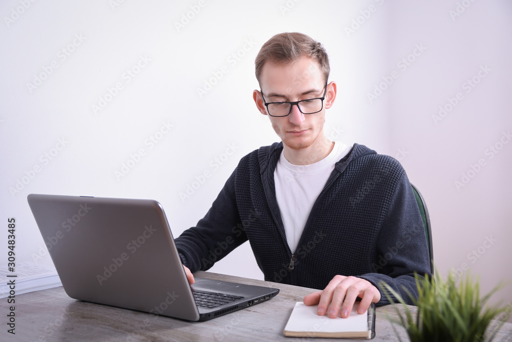 Portrait of young  business man sitting at his desk desktop laptop technology in the office.Internet marketing, finance, business concept