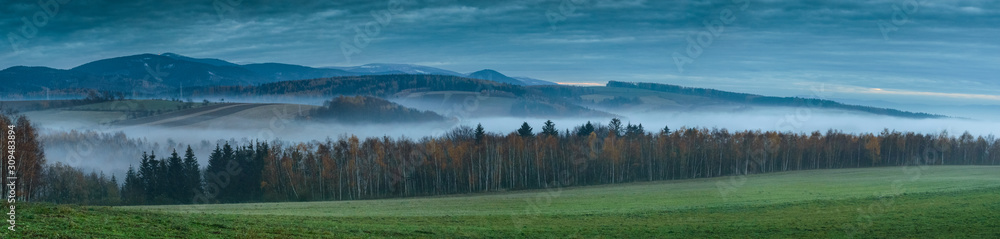 Fototapeta premium Panorama of the Sudetes mountains after sunset, flowing fog in the valleys.