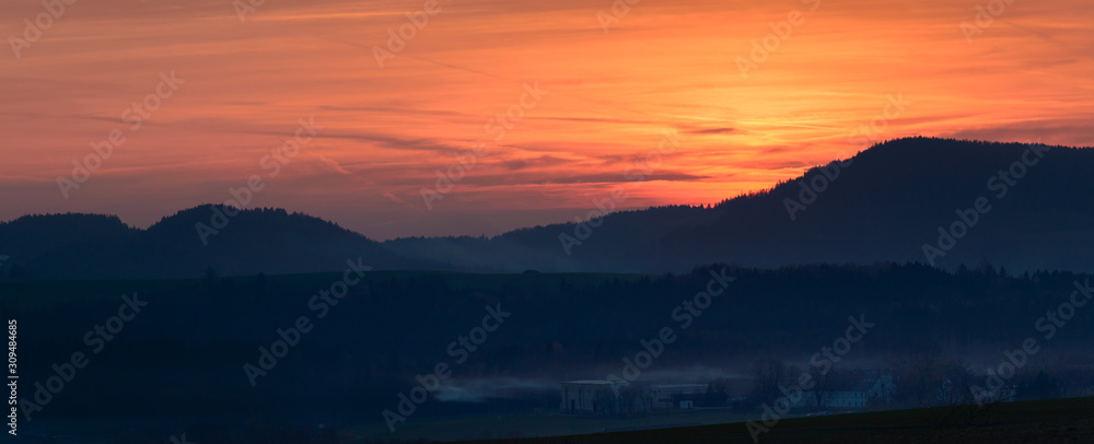 Orange sunset over the mountain valley.