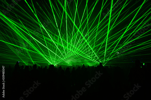 Fotografija People bathed in fog and laser light, laser show.