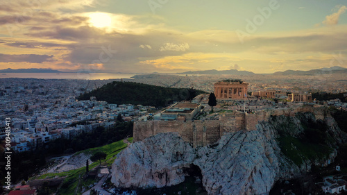 Aerial drone panoramic photo of beautiful sunset with golden colours and clouds over iconic Acropolis hill and Masterpice of Western ancient civilisation - the Parthenon, Athens, Attica, Greece