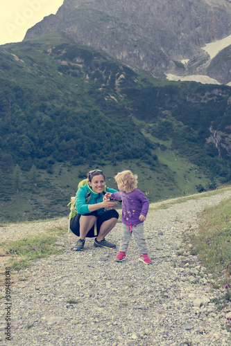 Mother and daughter hiking on a mountain path.