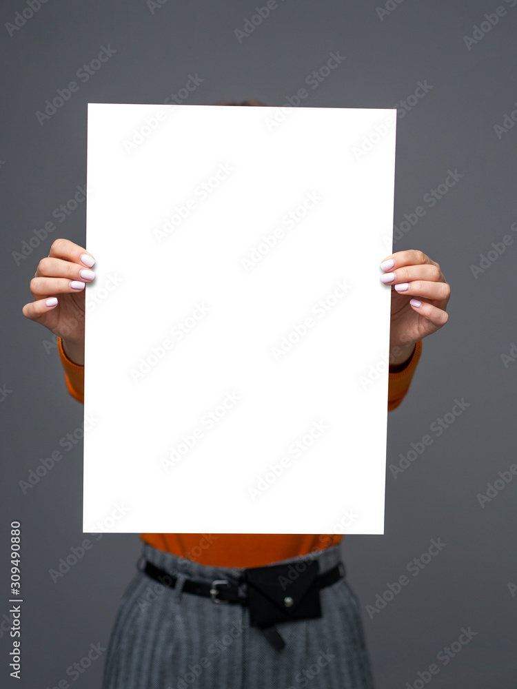 Stylish teen girl young with big paper sheet in her hands on gray